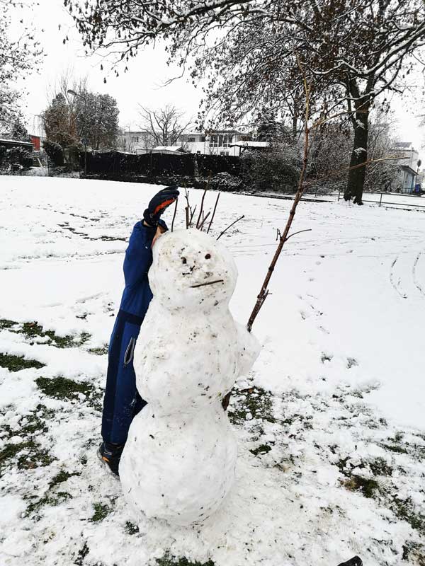 Ein Kind baut einen Schneemann