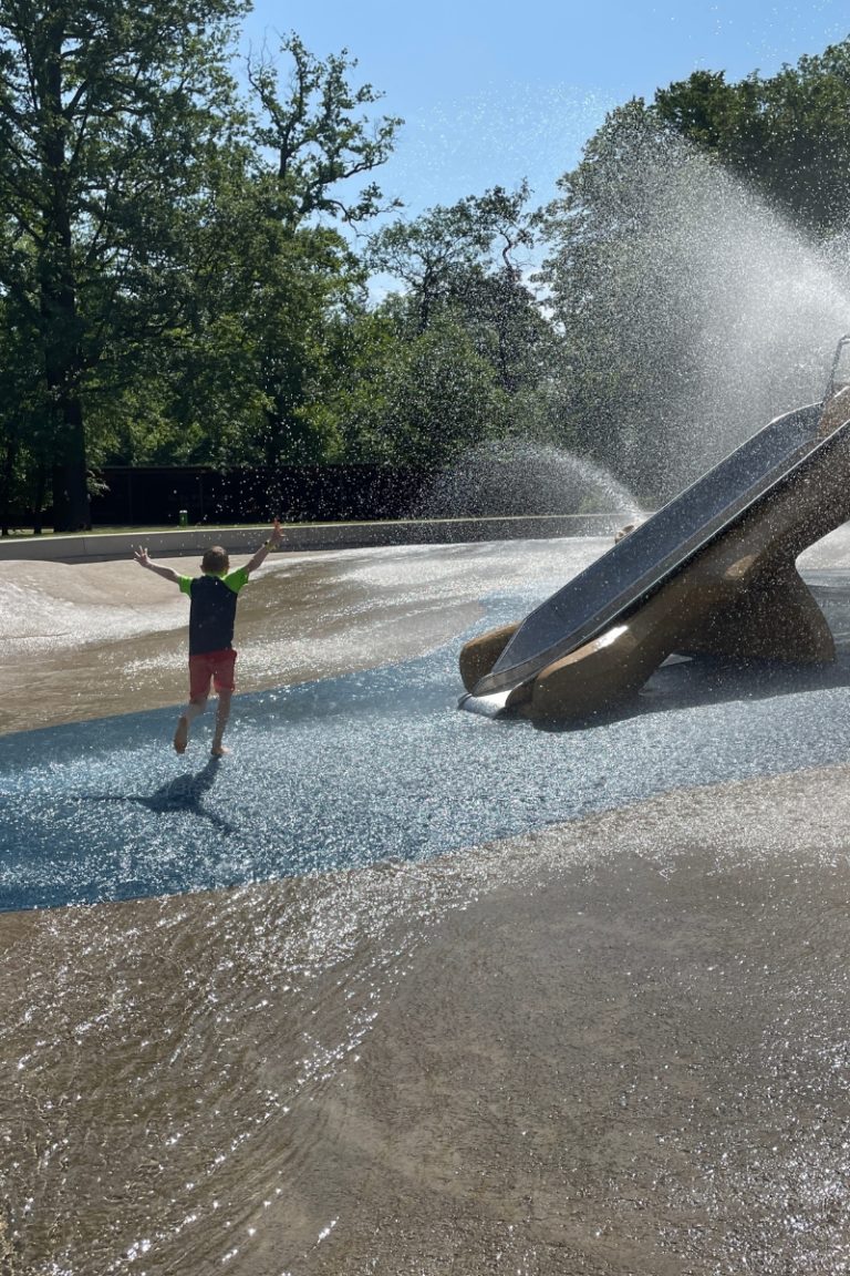 Kind rennt durch die Wasserspiele im Waldspielpark Frankfurt Schwanheim