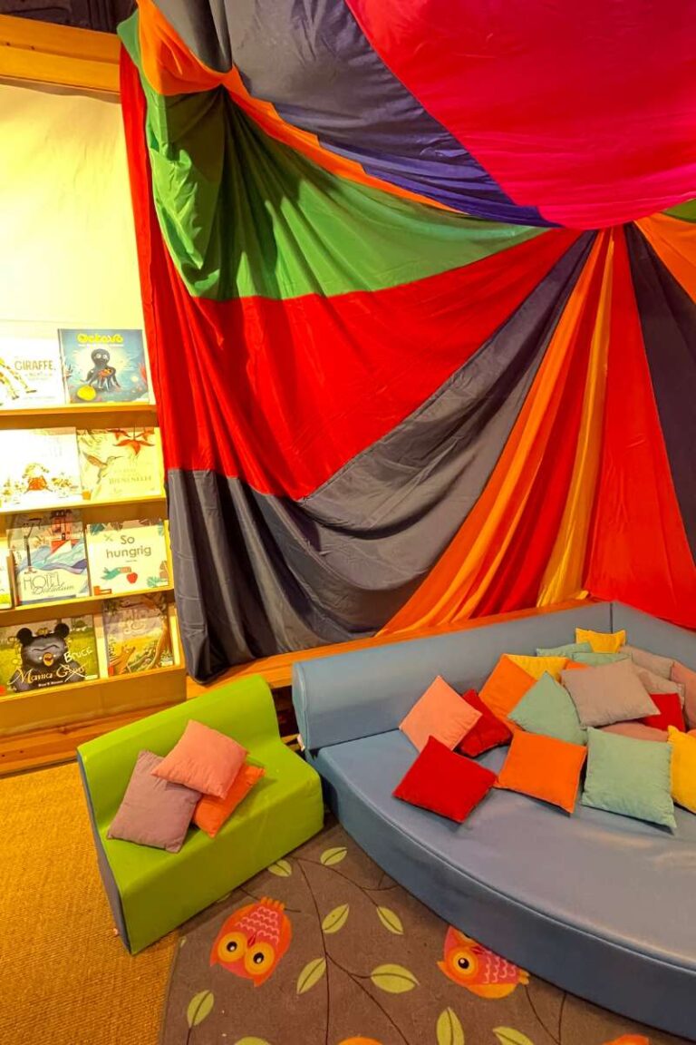 Eine Leseecke mit vielen Kissen und einem kleinen Sofa für Kinder zum Lesen bei der LeseEule in Frankfurt in den Römerhallen