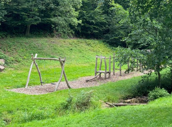 Spielplatz mit Klettergerüst und Schaukel direkt am Bach