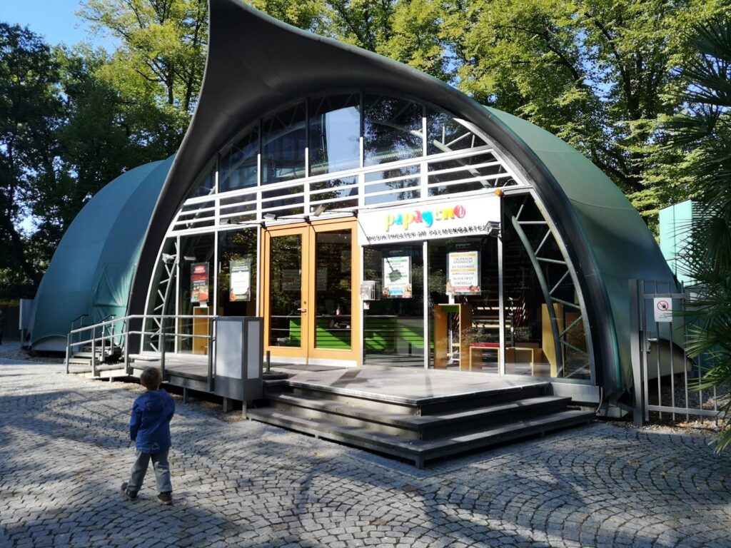 Kleinkind läuft auf das Papageno Musiktheater am Palmengarten in Frankfurt zu
